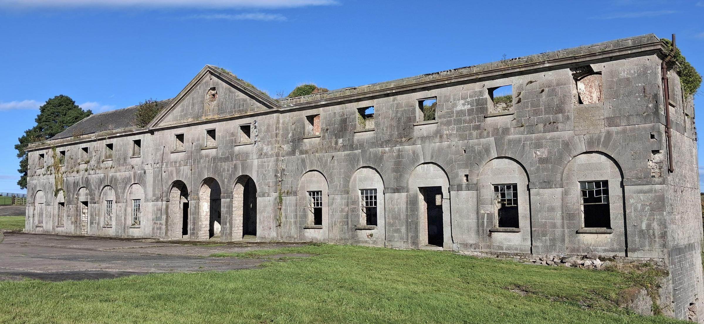 The front of the stable block: pediment, oculus and open arches